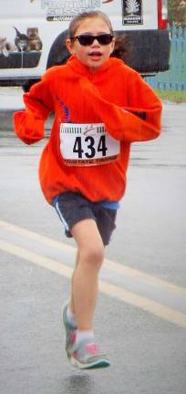 Milly Dobbs, 7, of Sparta bears the rain with a smirk and a sweatshirt.