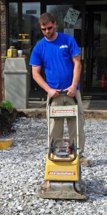 Adam Hayn of Adam Hayn Construction is shown leveling the base for the new walkway.
