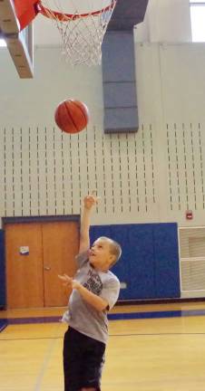 Nine year old Tristan Ortega of Newton shoots the basketball.