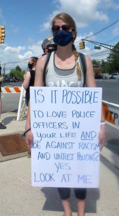 Kendahl Shortway, organizer of the event, holds sign: IT IS POSSIBLE TO LOVE P:OLICE OFFICERS IN YOUR LIFE AND BE AGAINST RACISM AND UNJUST POLICING? YES. LOOK AT ME.