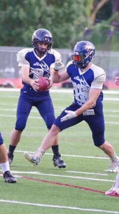 Sussex Stags quarterback Joe Enslin fakes a handoff to running back Cody La'Mour as the offensive line hold back the Jersey Shore Hurricanes.