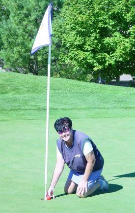 Buffy Whiting retrieves her ball from the par 3 2nd hole following her 1st hole-in-one.