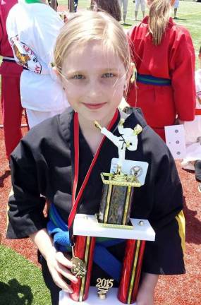 Caterina Dorsey proudly displays her trophy won during sparring competition.
