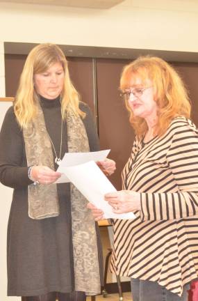 Board Secretary Christina riker asists with the swearing in of new board member Georgeanna Stoll.
