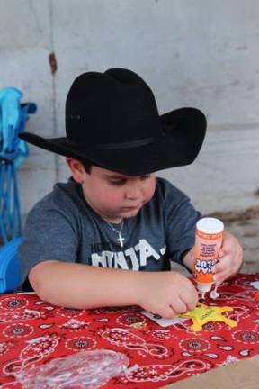 Ryan Rodriguez of Franklin makes his Sheriff badge at the Green Valley Rodeo.
