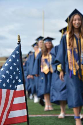 Class of 2023 president Natalia Arroyo leads a line of graduates.