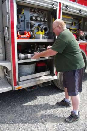 Cliffwood Lake resident and Highland Lakes firefighter Gene Bellusci removes some gear from one of two Highland Lakes fire engines that helped to draw attention to the Vernon Township Police Department&#x2019;s annual Child Safety Day.