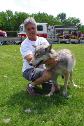Vinnie Reo of Wolf Visions is shown with Tecomah, a year old tundra wolf, which was born in Nevada and recently joined Reo's pack.