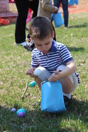 Cael Osborn of Wantage fills his bag with Easter eggs at the DAR Museum Easter egg hunt.