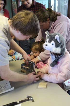 William assists Madeline Norwood Orsi of Wantage with a few staples on her suit feeder.