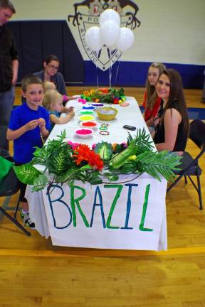 Visitors to the Brazil table where the kids had a chance to make colorful bracelets.