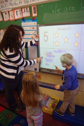 'Tools of the Mind' an educational head start PHOTO BY CHRIS WYMAN Walnut Ridge Primary School teacher Lesley Falgiano is shown as she works with a young student teaching him to count and then recognize the correct answer that corresponds to the number of stars shown on the electronic board.