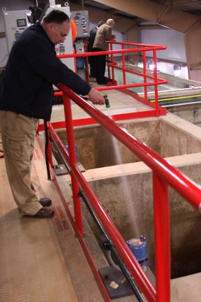 A look behind the scenes inside the water plant Coviello sprays water on holding tanks to cleanse them.