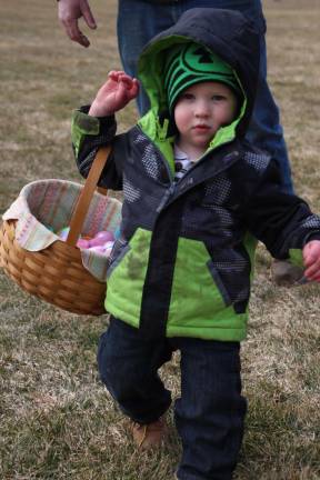 Gage DeGroat of Wantage balances his basket and searching for eggs and the Woodbourne Park egg hunt on Saturday.