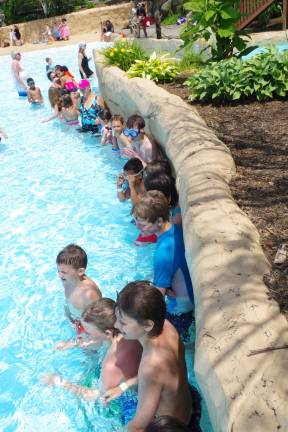 The children line up along the wall of the as they wait for the start of the Hightide Wavepool group swimming lesson.