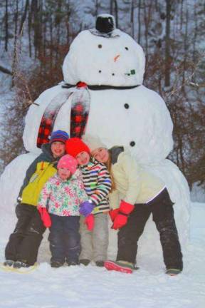 This photo submitted by Kari Casper shows Ben, Ella, Emma and Anna Casper enjoying another snow day building a snowman with their father.