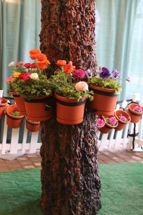 Flowers adorn a tree trunk.