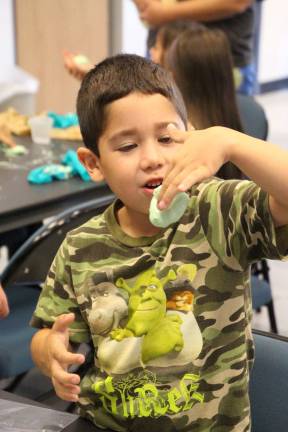 George Orellana of Wantage plays with non newtonian fluid (not solid and not liquid) that they made at the library called Gooey Gunk.
