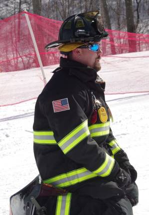 Snowboarder/Firefighter Trevor Badu waits as fellow team members head towards the starting line. He took up the final position on the team.
