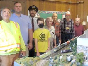 Members of the Sussex County Railroad Club pose near a replica of the Franklin Union Station (Photo by Janet Redyke)