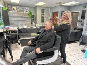 BC1 Cathy Permunian, owner of Black Comb, 188 Breakneck Road, Highland Lakes, offers Vernon Mayor Anthony Rossi a haircut at the barbershop’s grand opening Sunday, April 28. (Photo provided)