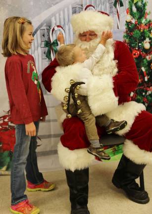 Emma Feichtl of Wantage watches her brother Luke give big hugs to Santa.