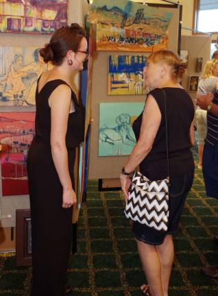 Artist Stephanie Roth, left, speaks to an attendee of the Highland Lakes Professional Artists&#xfe;&#xc4;&#xf4; Show about her artwork.