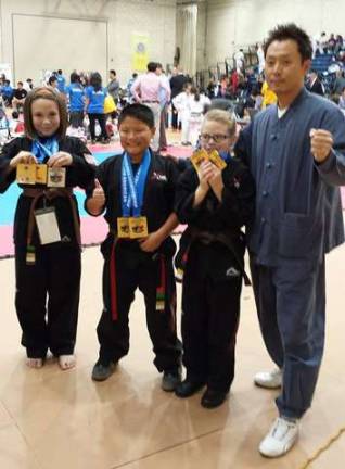 Three of Master Ken's students went to the 10th American Taekwondo Championship on Saturday, Nov. 8, in New York City. They won six gold and two silver medals in Form, Breaking and Sparring divisions. Pictured from left are: Kristina L. (Sussex Borough), Gabriel U. (Hardyston), Allison M. (Sussex) and Master Ken Lee. For more information, please call Master Ken's Xtreme Martial Arts Center in Hamburg at 973-827-1234.