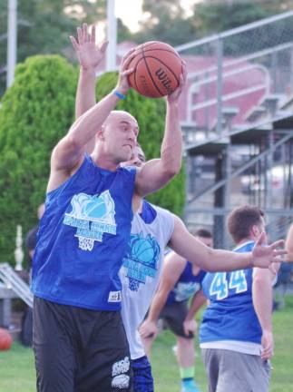 Team Smalley wins summer basketball league Team Tobin's Mike Tobin snatches the ball in midair during a rebound.