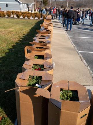 Boxes of wreaths line the sidewalk.
