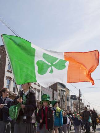 Newton goes green An unidentified girl carries a large Irish flag as she marches along.