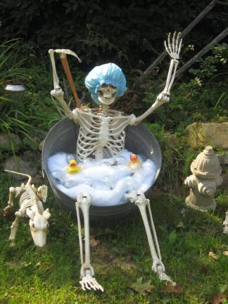 PHOTO BY JANET REDYKE Mr. Bones is again on display on Highland Lakes Road (Route 638). Last year, the man of bones sat in an easy chair, wearing a baseball cap and enjoying his favorite brew. This year he's scrubbing in a Halloween bathtub.