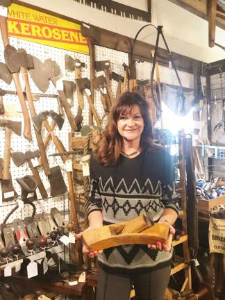 PHOTOS BY LAURIE GORDON Linda Mariconda, owner of Whitney House Antiques, holds a Coopers barrel-making sun plane from the 19th century.