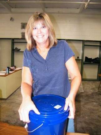 Volunteer Terri Peter of the Sussex United Methodist Church and Tranquility United Methodist Church seals a completed flood bucket.