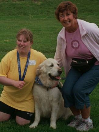 Taking a break between races, from left, Special Olympics athlete Carol Spilatros of Vernon gets up close and personal with Boomer, a golden retriever therapy dog with Therapy Dogs International, and his handler Linda Justesen of Newton.