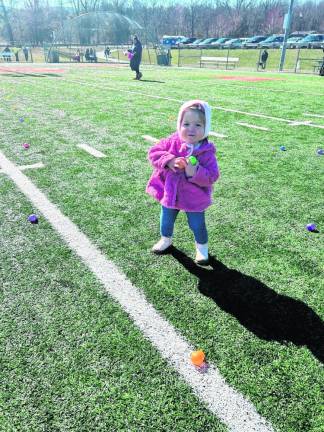 Sarabeth Ernberger, 1 1/2, of Warwick, N.Y., holds Easter eggs Sunday, March 24.