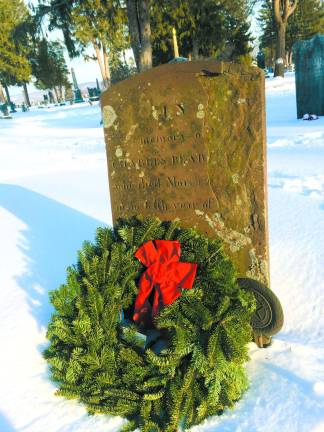 A wreath is laid at a grave by the local chapter of Daughters of the American Revolution.