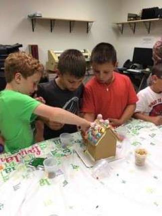 Kellen, Bret and Travis put finishing touches on their gingerbread house.