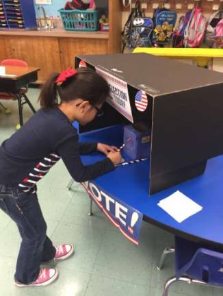 A 1st grade student casts her vote at the WRPS Mock Election