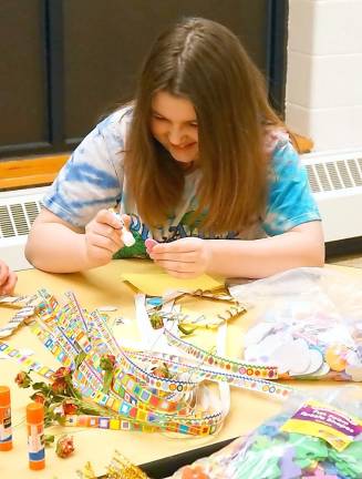 A student decorates a picture frame.