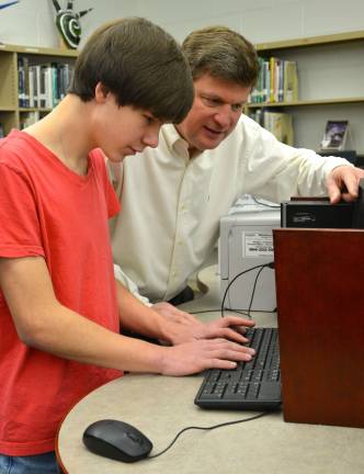 Student Andrew Wiik shows Stephen Denn, VTHS librarian, some of features he worked into the new library webpage which he designed.