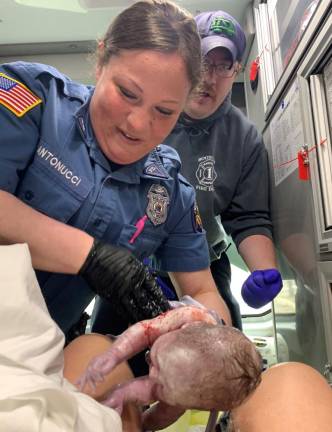 Officer Amy Antonucci helps deliver baby Juliana alongside one of the ambulance's EMTs. Photo provided.