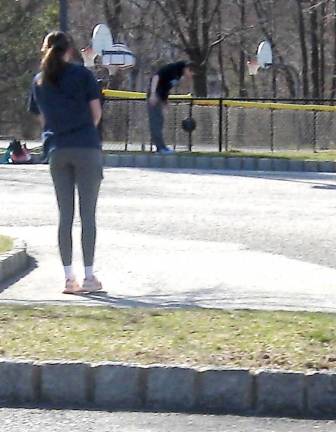 Friends distance themselves and lift weights outside due to gym closures.