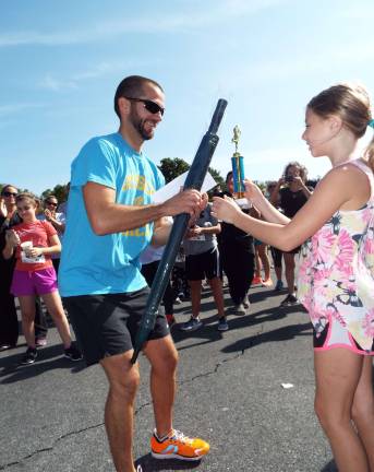 Wantage Recreation Commission hosts run/walk Sussex Middle School Principal Shane Schwarz, 33 of Highland Lakes--the overall race winner with a time of 19.02.1--receives his trophy for the accomplishment.