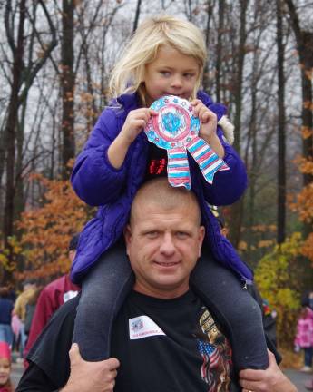 First grade student Kayli O'Rourke, 6, got a great seat atop her father Ed&#xfe;&#xc4;&#xf4;s shoulders during the veterans&#xfe;&#xc4;&#xf4;' parade at Walnut Ridge Primary School.
