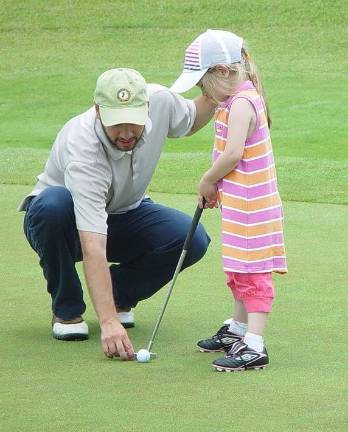 Crystal Springs hosts Father's Day golf Father Dan Chernowsky helps 5-year-old daughter Hazel line up her putt.