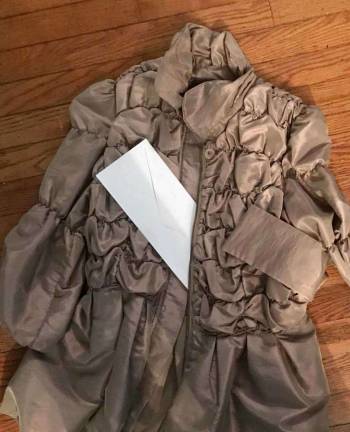 PHOTO BY LAURIE GORDONA coat and note ready to be donated to Pass It Along's Note in a Coat Drive.