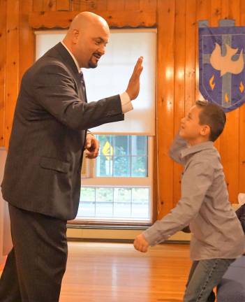 PHOTOS BY VERA OLINSKI From left, Pastor Michael Rojas &quot;High-5s&quot; congregant Joey Mancini.