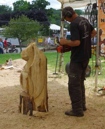 Chainsaw artist Kenny Scoggins of Artistry in Wood is shown creating a &#xfe;&#xc4;&#xfa;little dragon.&#xfe;&#xc4;&#xf9; Based in Heidelberg, Miss. This is their 11th year at the fair. During the day dozens of people at a time sat down and relaxed and watched him at work.