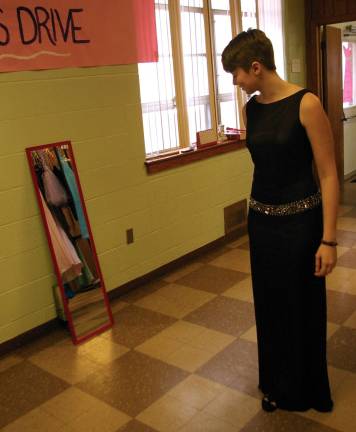 Kaitlyn Gallaugher, 17, of Highland Lakes, tries on one of the dresses that were available for free through a project organized by members of DECA&#xfe;&#xc4;&#xf4;s Vernon Chapter.
